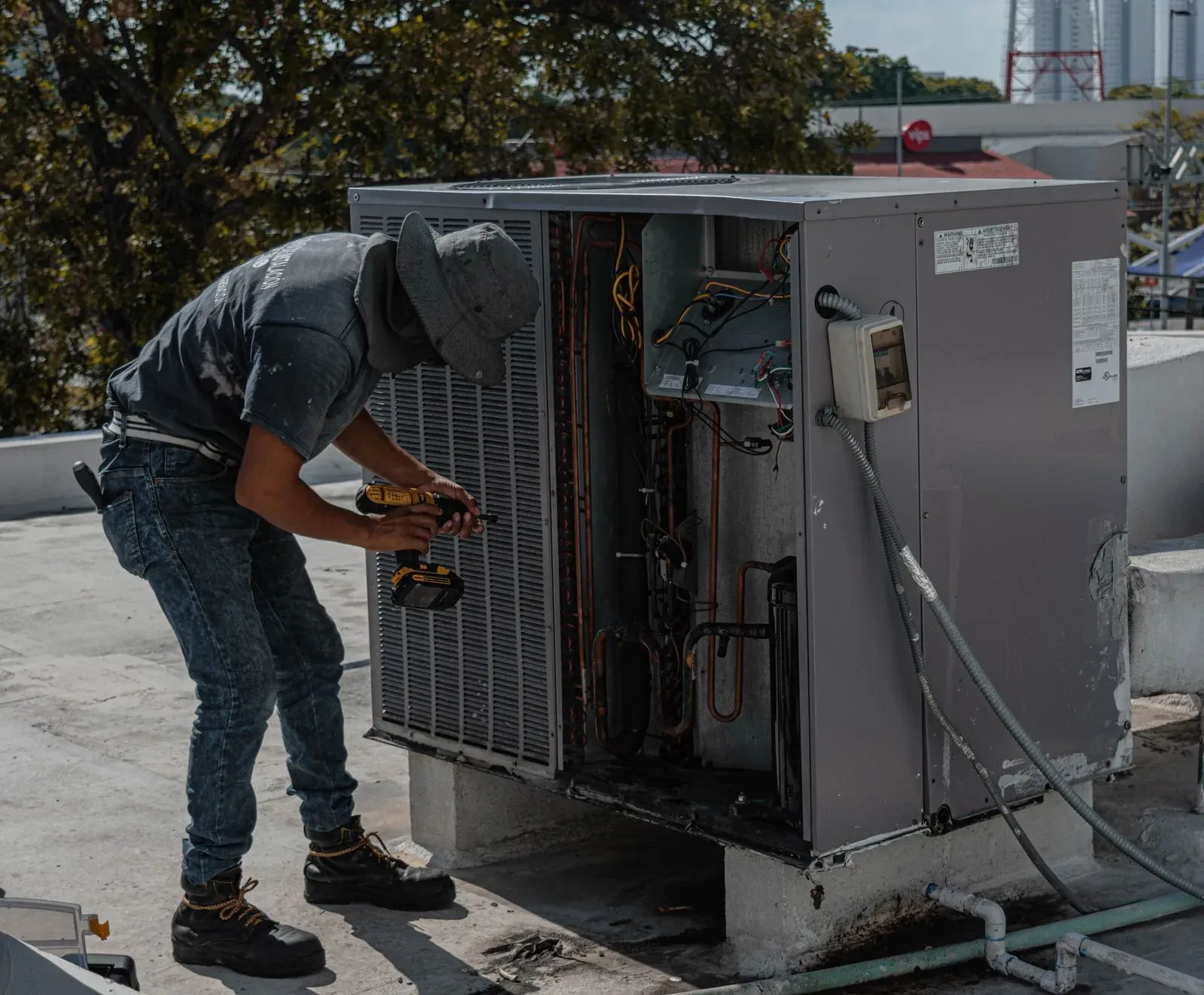 Técnico reparando una unidad de aire acondicionado en azotea (imagen ilustrativa).
